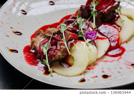 Gourmet roasted meat with berry sauce and pear slices fine dining restaurant plating Gourmet roasted meat with berry sauce and pear slices fine dining restaurant plating 136963944