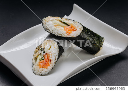 Temaki sushi hand roll with salmon cucumber and cream cheese on white plate Temaki sushi hand roll with salmon cucumber and cream cheese on white plate 136963963