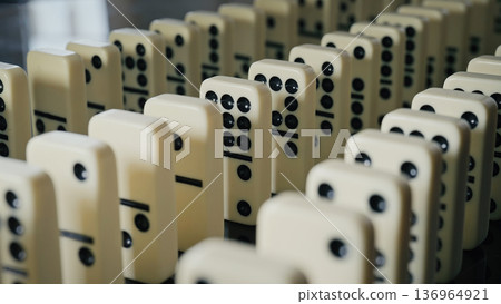 Falling domino pieces trigger a continuous chain reaction. Symbol of cause and effect Falling domino pieces trigger a continuous chain reaction. Symbol of cause and effect 136964921