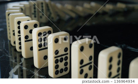 Falling domino pieces trigger a continuous chain reaction. Symbol of cause and effect 136964934