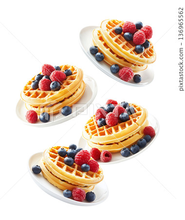 Stacked waffles topped with fresh berries in repeating layout isolated on white background, expressing a breakfast concept 136965562