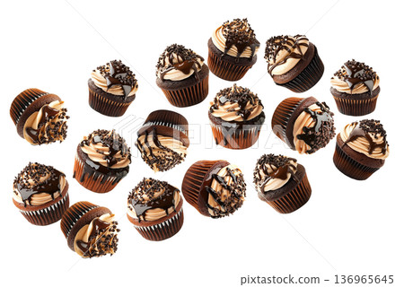 Chocolate cupcakes topped with creamy frosting, chocolate drizzle, and sprinkles on white background. Dessert and bakery concept 136965645