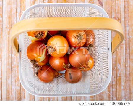 Yellow onion in basket on wooden table Yellow onion in basket on wooden table 136966589