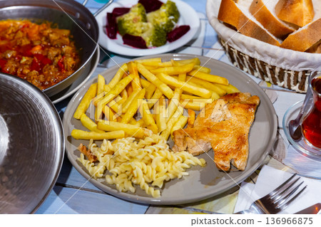 Turkish chicken chop with fried potatoes and fusilli 136966875
