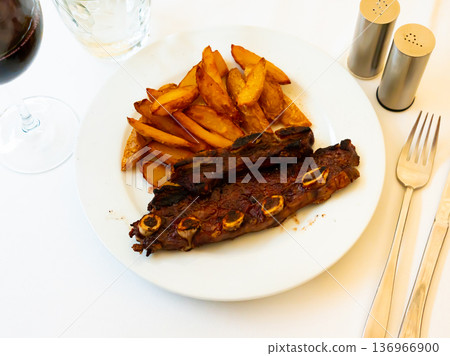 Grilled churrasco veal ribs with side dish of baked potatoes Grilled churrasco veal ribs with side dish of baked potatoes 136966900