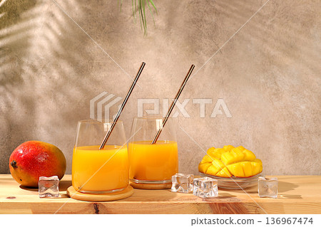 Homemade cocktail, juice, or lemonade with mango slices and ice on a sun-drenched kitchen table. Summer party concept. Refreshing summer diet drink recipe, detox diet and healthy lifestyle Homemade cocktail, juice, or lemonade with mango slices and ice on a sun-drenched kitchen table. Summer party concept. Refreshing summer diet drink recipe, detox diet and healthy lifestyle 136967474