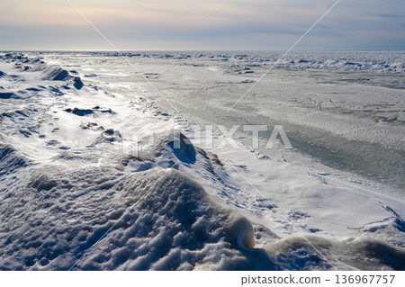 Frozen Baltic Sea Coastline with Snow and Ice Under Soft Winter Sunlight Frozen Baltic Sea Coastline with Snow and Ice Under Soft Winter Sunlight 136967757