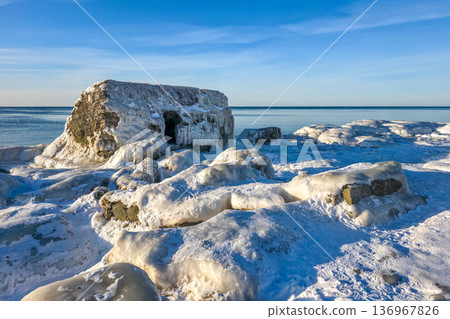 Icy and snowy Ruins of Historic Coastal Fortifications on Baltic Sea Shore in Liepaja, Latvia 136967826