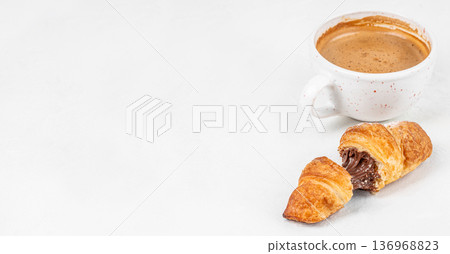 Chocolate filled croissant with coffee cup and copy space on white background Chocolate filled croissant with coffee cup and copy space on white background 136968823