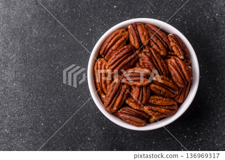 Peeled and roasted pecan nut as an ingredient for healthy food. Pecan nut as a food background 136969317