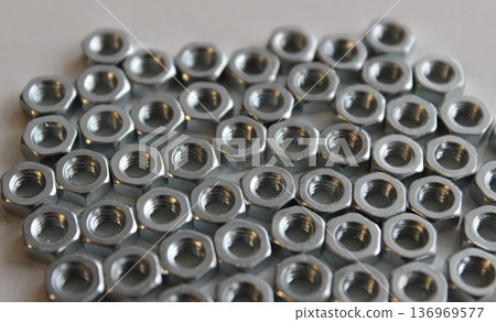 Steel Screw Nuts Laid Out On White Surface Texture Background Steel Screw Nuts Laid Out On White Surface Texture Background 136969577