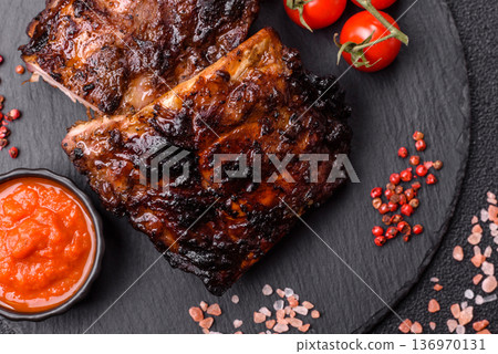 Grilled or barbecued pork or beef ribs, meat with red sauce for the dinner table. Grilled ribs Grilled or barbecued pork or beef ribs, meat with red sauce for the dinner table. Grilled ribs 136970131