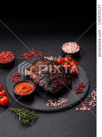 Grilled or barbecued pork or beef ribs, meat with red sauce for the dinner table. Grilled ribs Grilled or barbecued pork or beef ribs, meat with red sauce for the dinner table. Grilled ribs 136970137