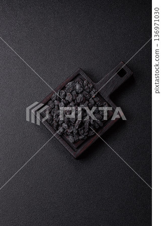 Sweet, dry black or blue raisins made from grapes are a healthy and nutritious food. Black raisins Sweet, dry black or blue raisins made from grapes are a healthy and nutritious food. Black raisins 136971030