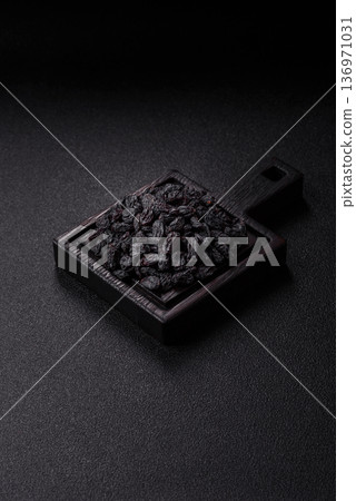 Sweet, dry black or blue raisins made from grapes are a healthy and nutritious food. Black raisins Sweet, dry black or blue raisins made from grapes are a healthy and nutritious food. Black raisins 136971031