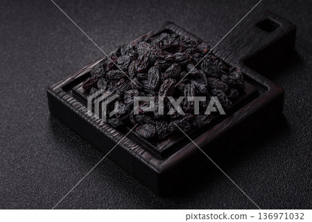 Sweet, dry black or blue raisins made from grapes are a healthy and nutritious food. Black raisins Sweet, dry black or blue raisins made from grapes are a healthy and nutritious food. Black raisins 136971032