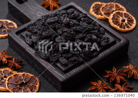 Sweet, dry black or blue raisins made from grapes are a healthy and nutritious food. Black raisins Sweet, dry black or blue raisins made from grapes are a healthy and nutritious food. Black raisins 136971040