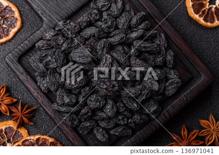 Sweet, dry black or blue raisins made from grapes are a healthy and nutritious food. Black raisins Sweet, dry black or blue raisins made from grapes are a healthy and nutritious food. Black raisins 136971041