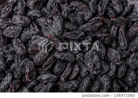 Sweet, dry black or blue raisins made from grapes are a healthy and nutritious food. Black raisins Sweet, dry black or blue raisins made from grapes are a healthy and nutritious food. Black raisins 136971060