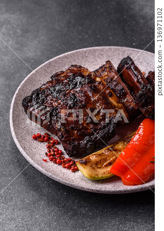 Grilled or barbecued pork or beef ribs, meat with red sauce for the dinner table. Grilled ribs Grilled or barbecued pork or beef ribs, meat with red sauce for the dinner table. Grilled ribs 136971102