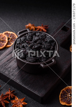 Sweet, dry black or blue raisins made from grapes are a healthy and nutritious food. Black raisins Sweet, dry black or blue raisins made from grapes are a healthy and nutritious food. Black raisins 136971179