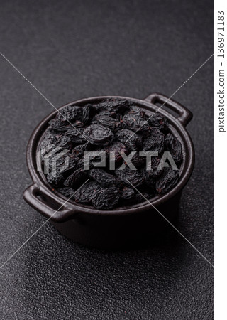 Sweet, dry black or blue raisins made from grapes are a healthy and nutritious food. Black raisins 136971183
