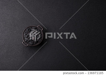 Sweet, dry black or blue raisins made from grapes are a healthy and nutritious food. Black raisins Sweet, dry black or blue raisins made from grapes are a healthy and nutritious food. Black raisins 136971185