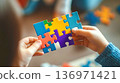 A child hands friend with autism card in form of connected colorful puzzle pieces 136971421