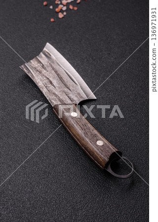 A kitchen cleaver or butcher's knife for cutting meat. A butcher's cleaver A kitchen cleaver or butcher's knife for cutting meat. A butcher's cleaver 136971931