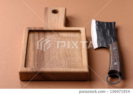 Empty wooden cutting board with a knife for food preparation. An empty wooden cutting board Empty wooden cutting board with a knife for food preparation. An empty wooden cutting board 136971954