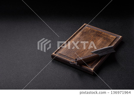 Empty wooden cutting board with a knife for food preparation. An empty wooden cutting board 136971964