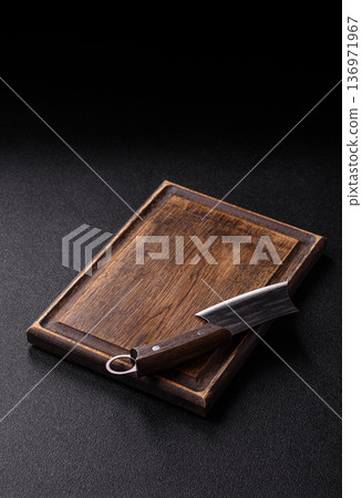 Empty wooden cutting board with a knife for food preparation. An empty wooden cutting board Empty wooden cutting board with a knife for food preparation. An empty wooden cutting board 136971967