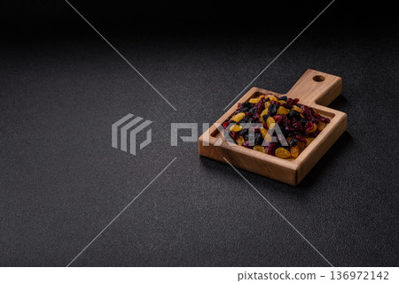 Dried cranberries, yellow and black sweet raisins as ingredients for a breakfast. Raisins and cranberries 136972142