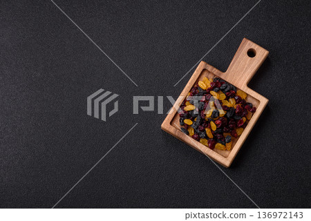 Dried cranberries, yellow and black sweet raisins as ingredients for a breakfast. Raisins and cranberries Dried cranberries, yellow and black sweet raisins as ingredients for a breakfast. Raisins and cranberries 136972143