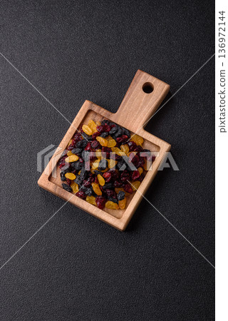 Dried cranberries, yellow and black sweet raisins as ingredients for a breakfast. Raisins and cranberries Dried cranberries, yellow and black sweet raisins as ingredients for a breakfast. Raisins and cranberries 136972144