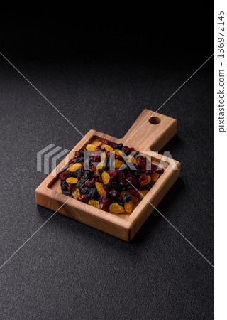 Dried cranberries, yellow and black sweet raisins as ingredients for a breakfast. Raisins and cranberries 136972145