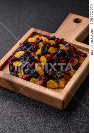 Dried cranberries, yellow and black sweet raisins as ingredients for a breakfast. Raisins and cranberries Dried cranberries, yellow and black sweet raisins as ingredients for a breakfast. Raisins and cranberries 136972149