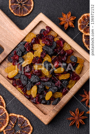 Dried cranberries, yellow and black sweet raisins as ingredients for a breakfast. Raisins and cranberries Dried cranberries, yellow and black sweet raisins as ingredients for a breakfast. Raisins and cranberries 136972152