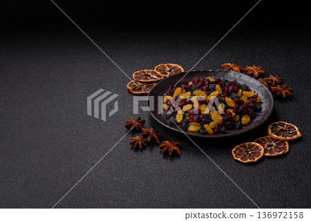Dried cranberries, yellow and black sweet raisins as ingredients for a breakfast. Raisins and cranberries 136972158