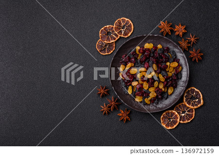 Dried cranberries, yellow and black sweet raisins as ingredients for a breakfast. Raisins and cranberries Dried cranberries, yellow and black sweet raisins as ingredients for a breakfast. Raisins and cranberries 136972159