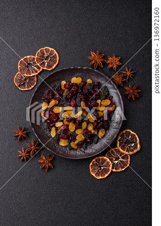 Dried cranberries, yellow and black sweet raisins as ingredients for a breakfast. Raisins and cranberries Dried cranberries, yellow and black sweet raisins as ingredients for a breakfast. Raisins and cranberries 136972160