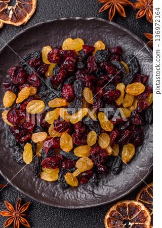 Dried cranberries, yellow and black sweet raisins as ingredients for a breakfast. Raisins and cranberries Dried cranberries, yellow and black sweet raisins as ingredients for a breakfast. Raisins and cranberries 136972164