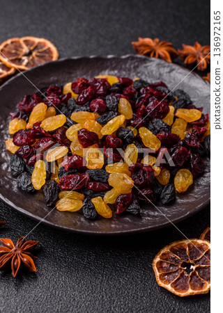 Dried cranberries, yellow and black sweet raisins as ingredients for a breakfast. Raisins and cranberries 136972165