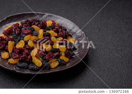 Dried cranberries, yellow and black sweet raisins as ingredients for a breakfast. Raisins and cranberries 136972166