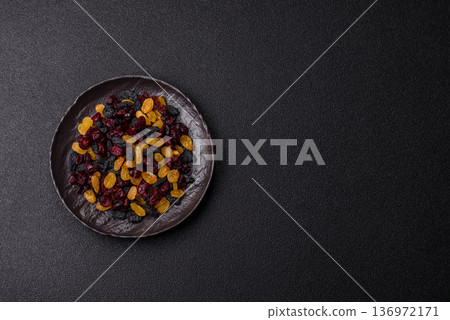 Dried cranberries, yellow and black sweet raisins as ingredients for a breakfast. Raisins and cranberries Dried cranberries, yellow and black sweet raisins as ingredients for a breakfast. Raisins and cranberries 136972171