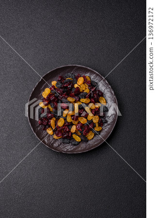 Dried cranberries, yellow and black sweet raisins as ingredients for a breakfast. Raisins and cranberries 136972172