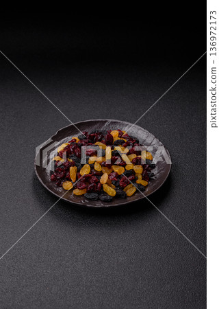Dried cranberries, yellow and black sweet raisins as ingredients for a breakfast. Raisins and cranberries Dried cranberries, yellow and black sweet raisins as ingredients for a breakfast. Raisins and cranberries 136972173