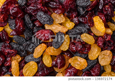 Dried cranberries, yellow and black sweet raisins as ingredients for a breakfast. Raisins and cranberries Dried cranberries, yellow and black sweet raisins as ingredients for a breakfast. Raisins and cranberries 136972174
