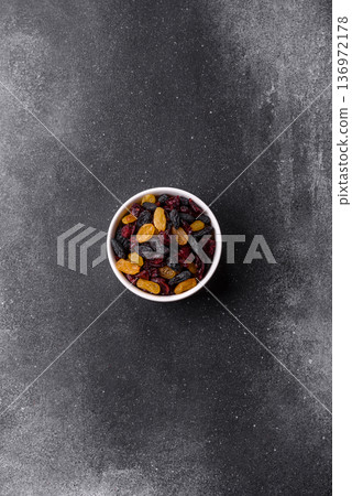 Dried cranberries, yellow and black sweet raisins as ingredients for a breakfast. Raisins and cranberries 136972178