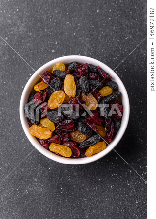 Dried cranberries, yellow and black sweet raisins as ingredients for a breakfast. Raisins and cranberries 136972182